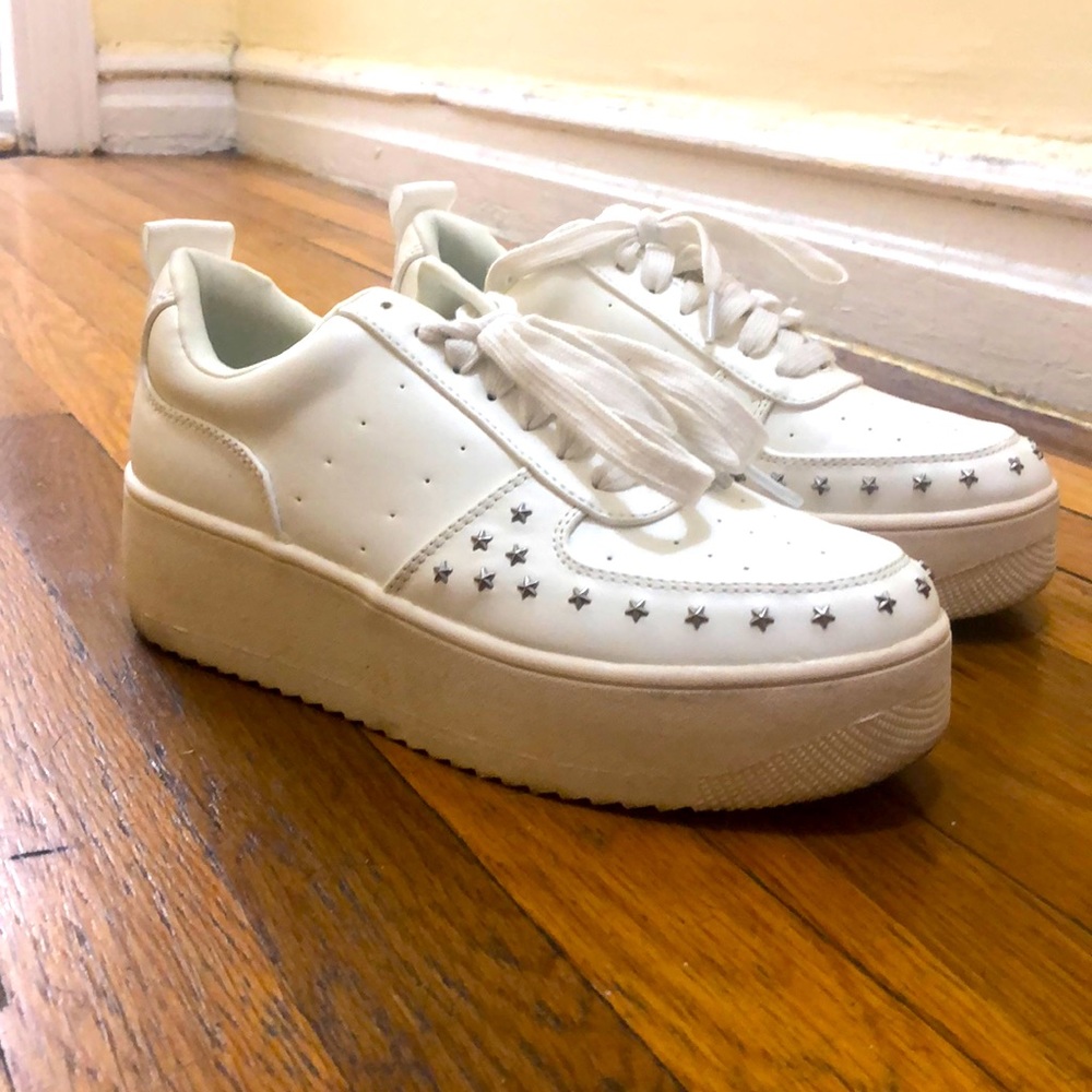 White platform sneakers with studs.
